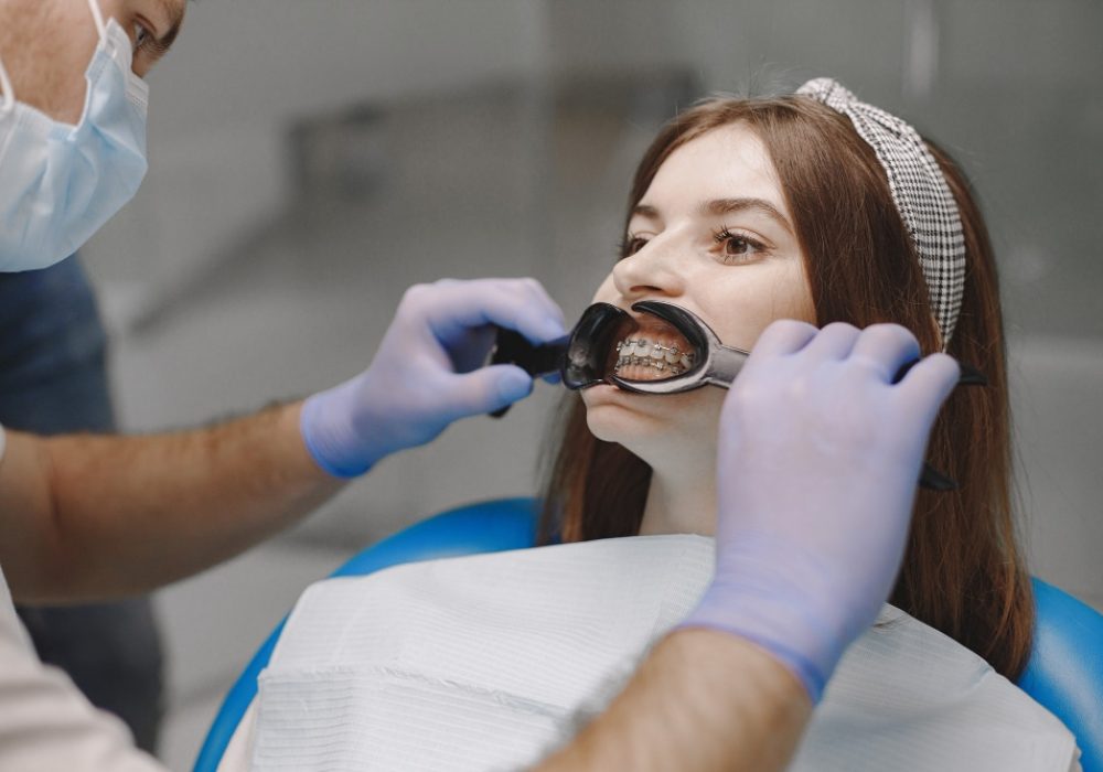 female-patient-with-braces-has-dental-examination-at-dentist-office-woman-wearing-white-clothes