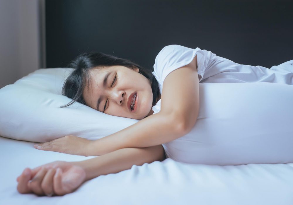 woman-sleeping-on-the-bed-and-grinding-teethtiredness-and-stress